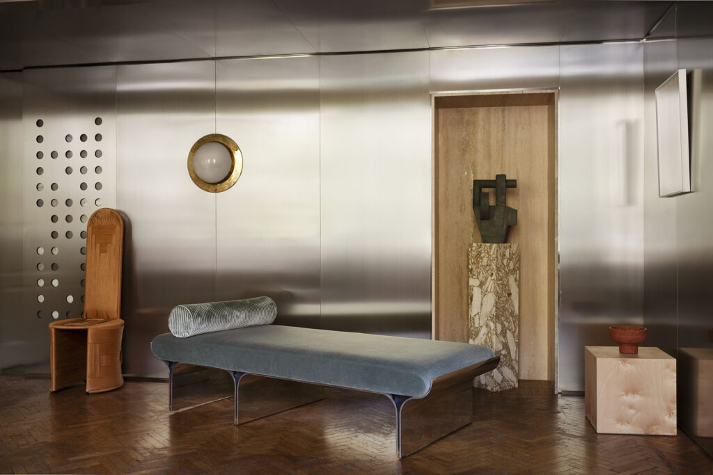 Boiserie in acciaio inox su misura con daybed e portale in travertino, realizzazione Tempora per Studiopepe