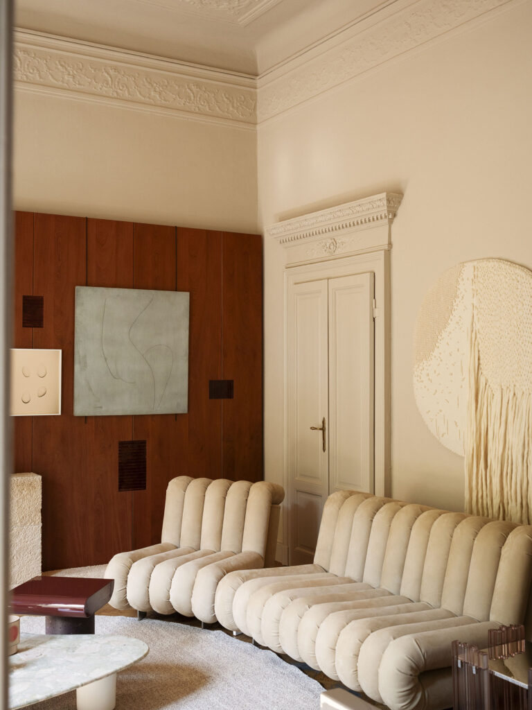 Boiserie in legno su misura con inserti a contrasto e divano modulare, realizzazione Tempora per The Intimacy