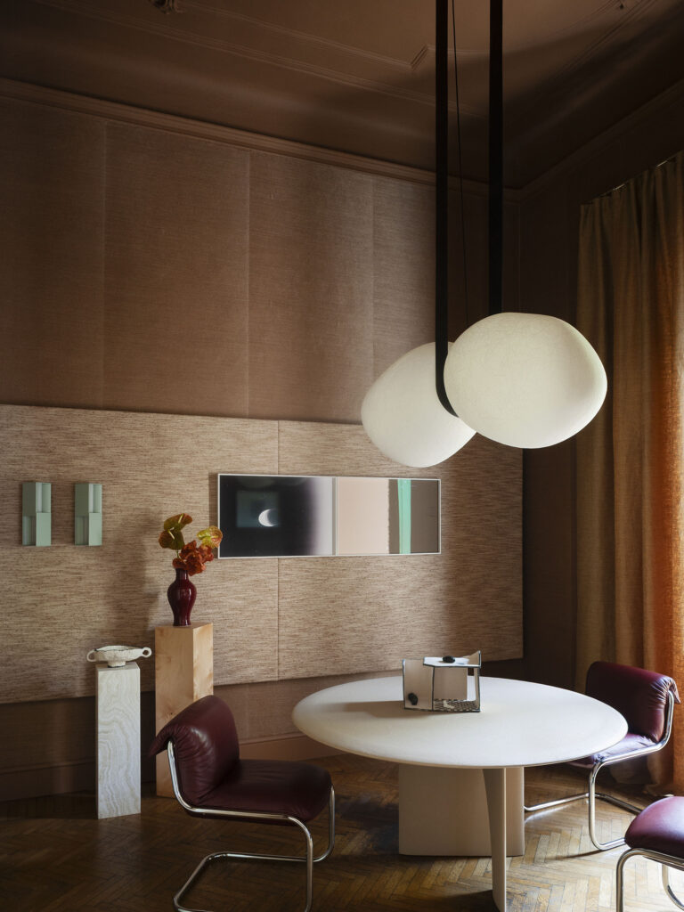 Dining room with bespoke wall and ceiling cladding, round table and cocoon pendant lamps